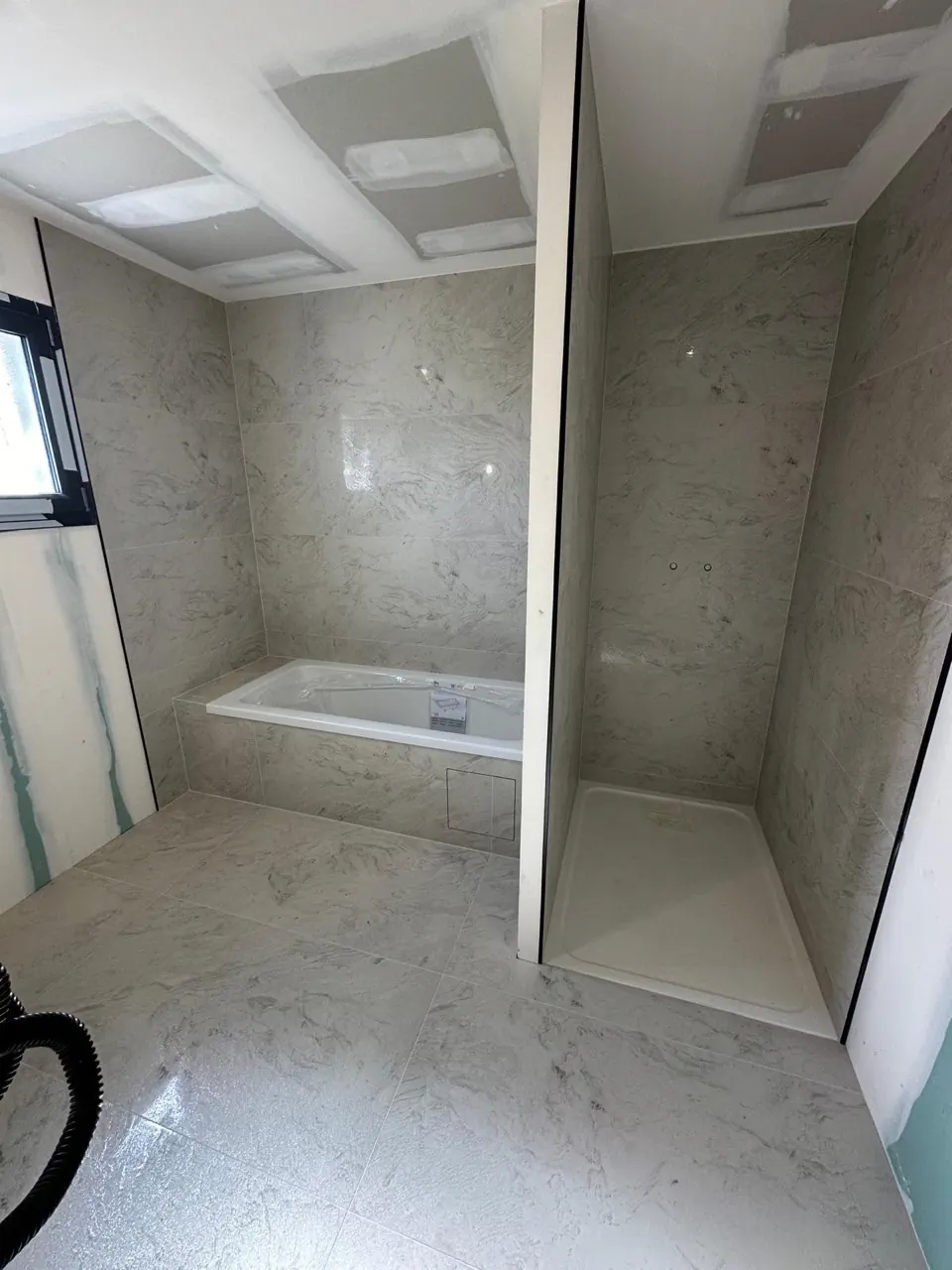 Salle de bain terminée par BATI-CAR avec carrelage et finitions soignées